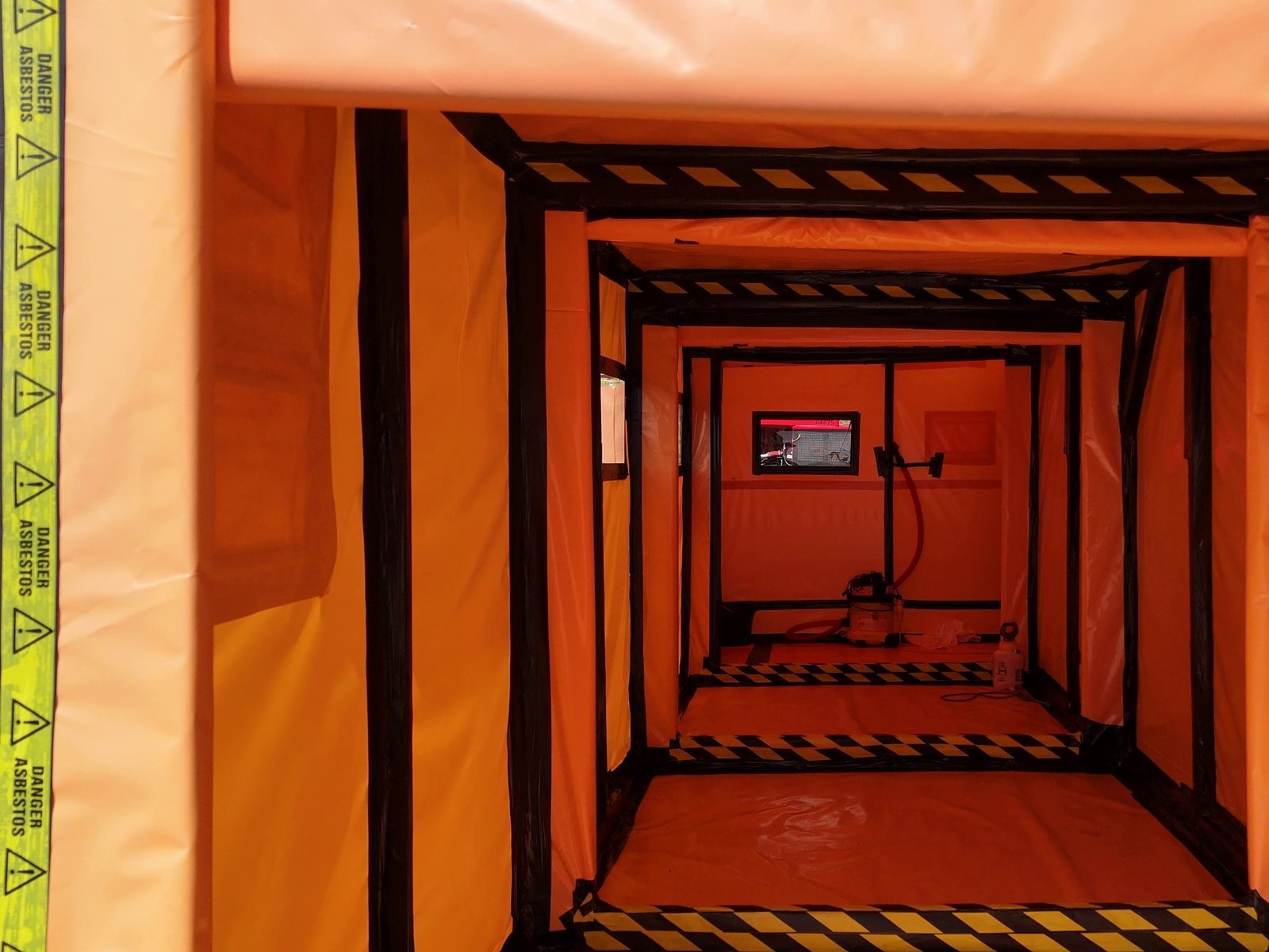 Orange controlled asbestos work area inside the old school
